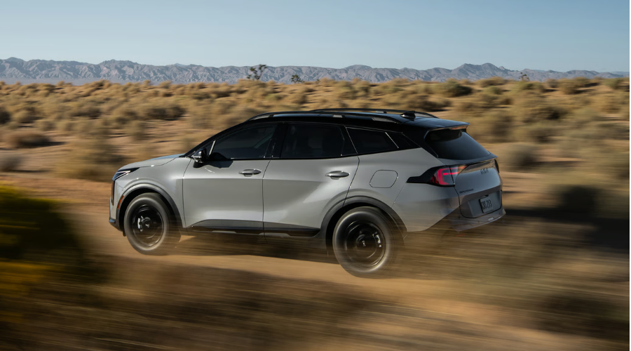 A dynamic profile shot of the 2026 Kia Sportage showcasing active handling and performance capabilities for drivers navigating sudden weather shifts in Waukegan IL.